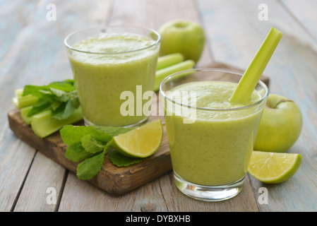 Frullato di mela verde, il sedano e la calce e su sfondo di legno Foto Stock