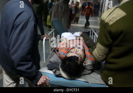 Srinagar, Indiano-controllato del Kashmir. Xiv Apr, 2014. Un poliziotto ferito viene portato su una barella in un ospedale di Srinagar, capitale estiva di Indiano-Kashmir controllata, 14 aprile 2014. Un altro poliziotto è stato ferito lunedì nella feroce gunfight il secondo giorno tra militanti e truppe indiane in Indian- controllato il Kashmir, la polizia ha detto. © Javed Dar/Xinhua/Alamy Live News Foto Stock