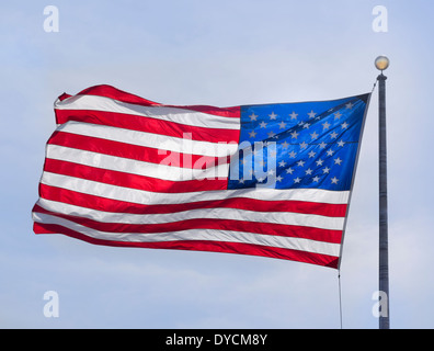 Bandiera americana che fluttua nel vento sotto un cielo nuvoloso Foto Stock