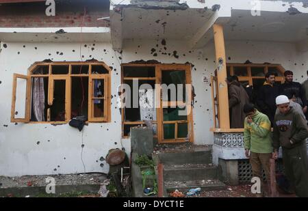 Srinagar, Indiano-controllato del Kashmir. Xiv Apr, 2014. Le persone si raccolgono al di fuori di un proiettile-riddled casa dove le truppe indiane hanno ucciso due militanti della periferia di Srinagar, la capitale estiva di Indiano-Kashmir controllata, 14 aprile 2014. Due militanti del Lashkar-e-Toiba (LET) militante outfit sono stati uccisi e due indiani poliziotti sono stati feriti Lunedi in una 20-ora-lunga gunfight in indiano-Kashmir controllata, la polizia ha detto. © Javed Dar/Xinhua/Alamy Live News Foto Stock