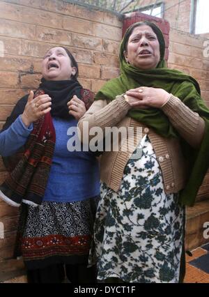 Srinagar, Indiano-controllato del Kashmir. Xiv Apr, 2014. Le donne del Kashmir urlate al di fuori di un proiettile-riddled casa dove le truppe indiane hanno ucciso due militanti della periferia di Srinagar, la capitale estiva di Indiano-Kashmir controllata, 14 aprile 2014. Due militanti del Lashkar-e-Toiba (LET) militante outfit sono stati uccisi e due indiani poliziotti sono stati feriti Lunedi in una 20-ora-lunga gunfight in indiano-Kashmir controllata, la polizia ha detto. © Javed Dar/Xinhua/Alamy Live News Foto Stock