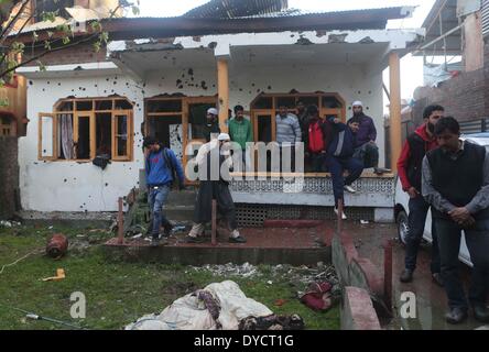 Srinagar, Indiano-controllato del Kashmir. Xiv Apr, 2014. Le persone si raccolgono al di fuori di un proiettile-riddled casa dove le truppe indiane hanno ucciso due militanti della periferia di Srinagar, la capitale estiva di Indiano-Kashmir controllata, 14 aprile 2014. Due militanti del Lashkar-e-Toiba (LET) militante outfit sono stati uccisi e due indiani poliziotti sono stati feriti Lunedi in una 20-ora-lunga gunfight in indiano-Kashmir controllata, la polizia ha detto. © Javed Dar/Xinhua/Alamy Live News Foto Stock