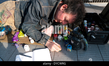 British chewing gum artista Ben Wilson pittura mentre giaceva sul Millennium Bridge a Londra England Regno Unito KATHY DEWITT Foto Stock