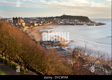 La mattina presto in primavera sulla baia del nord, mostrando il Grand Hotel, di un complesso termale e il Castello, Scarborough, North Yorkshire, Regno Unito Foto Stock