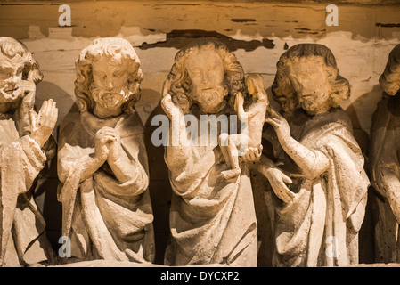 BRUGES, Belgio — Un portale in pietra gotica che combina l'iconografia della Vergine Maria e del giudizio universale è esposto al Sint-Janshospitaal (Old St. John's Hospital). Il portale del XIII secolo presenta scene scolpite tra cui la morte della Vergine, Cristo con intercessori e figure apostoliche. Questo elemento architettonico dimostra l'influenza dello stile gotico della Francia settentrionale sull'arte religiosa belga medievale. Foto Stock