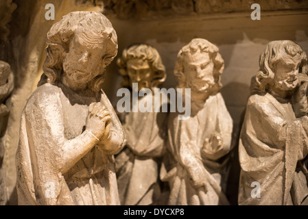 BRUGES, Belgio — Un portale in pietra gotica che combina l'iconografia della Vergine Maria e del giudizio universale è esposto al Sint-Janshospitaal (Old St. John's Hospital). Il portale del XIII secolo presenta scene scolpite tra cui la morte della Vergine, Cristo con intercessori e figure apostoliche. Questo elemento architettonico dimostra l'influenza dello stile gotico della Francia settentrionale sull'arte religiosa belga medievale. Foto Stock