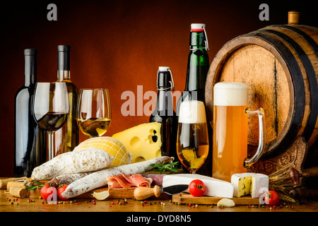 Natura morta con vino e birra, cibo tradizionale, formaggio e salsicce Foto Stock