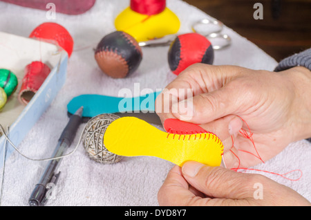 Artigianali in pelle, maschio mani tradizionale per cucire palloni da sport Foto Stock