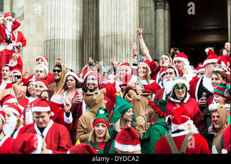 Centinaia di Babbo Natale raccogliere sui gradini della cattedrale di San Paolo per celebrare il Santacon annuale. Foto Stock