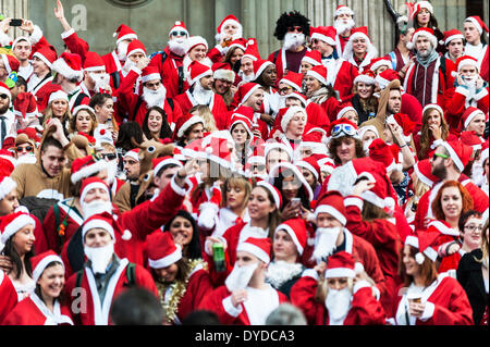 Centinaia di Babbo Natale raccogliere sui gradini della cattedrale di San Paolo per celebrare il Santacon annuale. Foto Stock