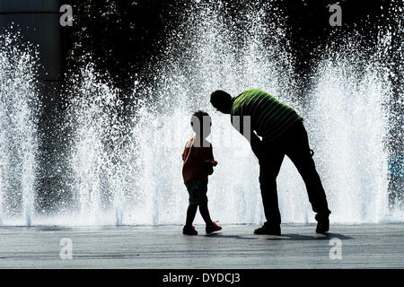 Un padre e figlio giocando con le fontane sulla South Bank di Londra. Foto Stock