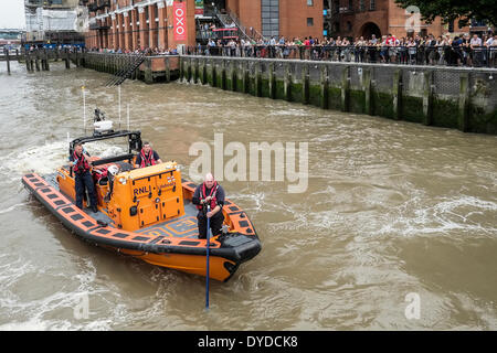 Il pubblico guarda su come l'equipaggio della barca RNLI Hurley Burly cerca il fiume Tamigi per un corpo. Foto Stock