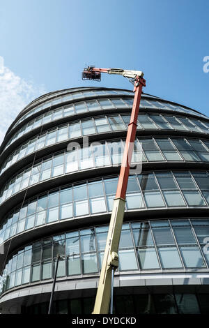 I lavoratori con una buona testa per altezze preparare per effettuare la manutenzione su windows del Municipio di Londra. Foto Stock