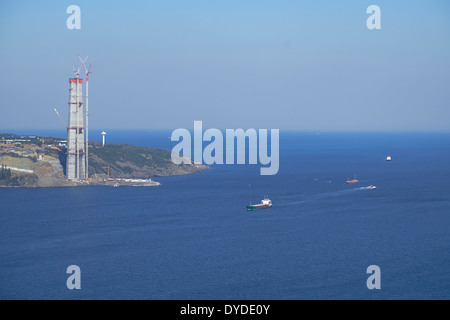 Contenitore nave passando il nuovo terzo ponte che è in costruzione sul Bosforo, Istanbul, Turchia. Foto Stock