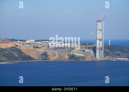 Contenitore nave passando il nuovo terzo ponte che è in costruzione sul Bosforo, Istanbul, Turchia. Foto Stock