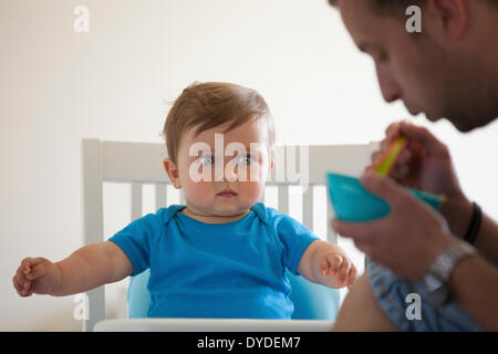 Baby boy essendo alimentato da suo padre. Foto Stock