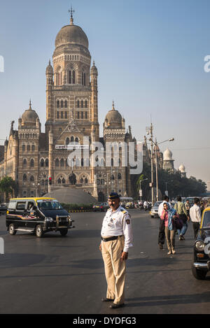 Un poliziotto del traffico osserva il traffico vicino alla sede della corporazione municipale di maggiore di Mumbai. Foto Stock