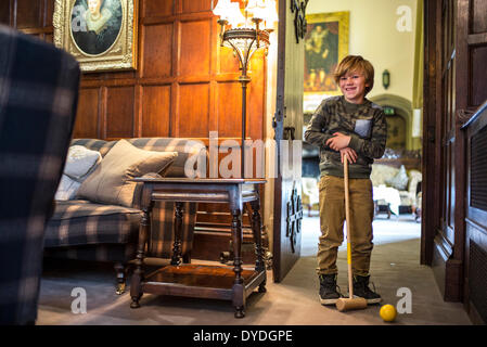 Un bambino gioca croquet in casa al Castello di Thornbury. Foto Stock