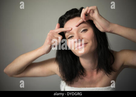 Una bella ragazza impertinente spremendo la sua fronte. Foto Stock