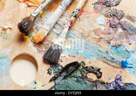 Tre utilizzate spazzole di vernice su legno tavolozza artistica Foto Stock