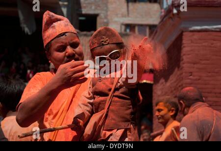 Bhaktapur, Nepal. 15 apr 2014. Un bambino getta polvere vermillion durante il Sindur Jatra festival a Thimi, Bhaktapur, Nepal, 15 aprile 2014. Sindur Jatra, o polvere di Vermiglio Festival è stato tenuto in Thimi per celebrare il nepalese Anno Nuovo. © Pratap Thapa/Xinhua/Alamy Live News Foto Stock