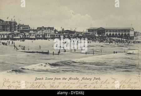 Una scena della spiaggia dall'Arcade di Asbury Park, New Jersey, che mostra i bagnanti lungo la riva, con il lungomare e gli hotel che offrono uno sguardo nostalgico alla vita costiera dello stato. Foto Stock