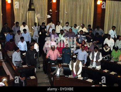 Muttahida Qaumi Movement (MQM) membri stanno protestando in Sindh Assembly quando sedia vice presidente non consentiva un di interrompere il moto del MQM MPA Muhammad Hussain contro le presunte uccisioni extragiudiziali Partito dei lavoratori, molestie, insicurezza e minacce alla gente di Karachi, martedì 15 aprile, 2014. Foto Stock