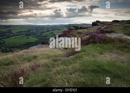 Cielo tempestoso oltre il Derwent valley visto dal bordo Curbar accanto a fioritura heather, il Parco Nazionale di Peak District, Derbyshire, Inghilterra Foto Stock