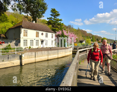 Walkers passando di palude e di bloccaggio della serratura del portiere casa sul Fiume Tamigi vicino a Henley-on-Thames,Oxfordshire, Inghilterra, Regno Unito nella primavera. Foto Stock