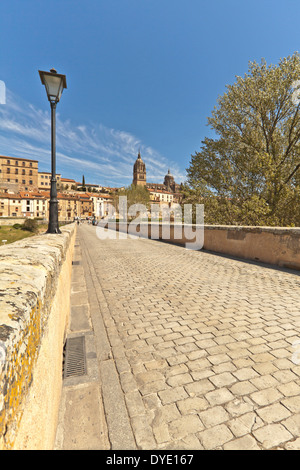 Basso angolo vista sul Puente Romano a.k.a. il vecchio ponte romano e la nuova cattedrale, Salamanca, Castilla y León, Spagna. Foto Stock