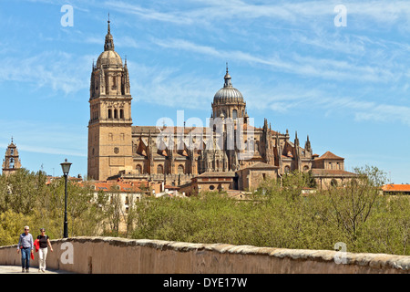 Persone che passeggiano sul Puente Romano a.k.a. il vecchio ponte romano con vista sul Duomo Nuovo, Salamanca, Castilla y León, Spagna. Foto Stock