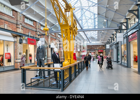 Gli amanti dello shopping, negozi & vecchi macchinari presso la rampa convertito lavora, ora McArthur Glen Designer Outlet Village a Swindon, Wiltshire Foto Stock