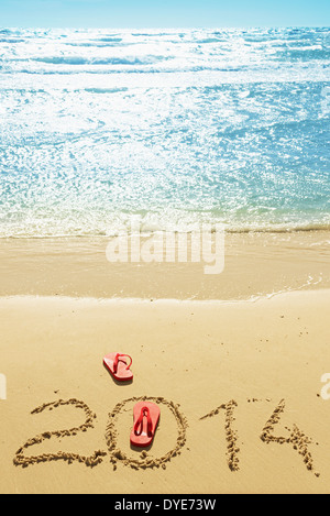 Red flip flop e cifre 2014 sulla spiaggia di sabbia.Concetto di vacanze estive e nuovo anno Foto Stock