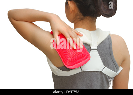 Donna mettendo un hot pack per il suo dolore alla spalla Foto Stock