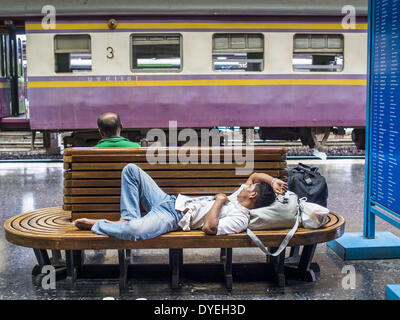 Bangkok, Tailandia. Xvi Apr, 2014. Un uomo dorme su di un banco prima di salire a bordo di un treno per portarlo a casa dopo il Songkran vacanza. Thai autostrade, treni e autobus sono stati imballati mercoledì come Thais iniziato a ritornare a casa dopo la lunga pausa Songkran. Songkran è normalmente di tre giorni lungo ma questo anno molti thailandesi avevano almeno un giorno supplementare off perché la vacanza è iniziato domenica, così molti thailandesi ha iniziato il viaggio il venerdì della scorsa settimana. Credit: Jack Kurtz/ZUMAPRESS.com/Alamy Live News Foto Stock