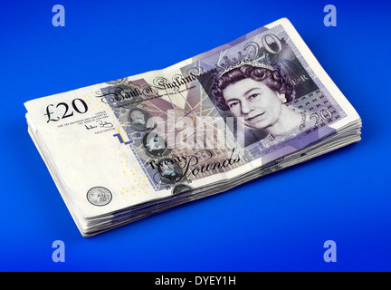 Una pila di venti POUND NOTE SU UNO SFONDO BLU Foto Stock