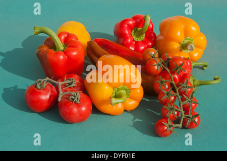 Pomodori ciliegia Chili e peperoni su sfondo verde Foto Stock