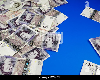 Venti pound note sparse su uno sfondo blu Foto Stock