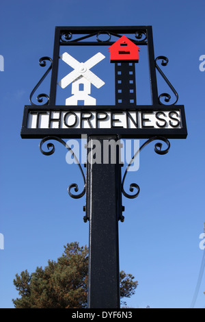 Segno di villaggio resort costiero di Thorpeness, Suffolk, Inghilterra, Regno Unito. Cartello include pietre miliari locali della casa nel cielo e il mulino a vento Foto Stock