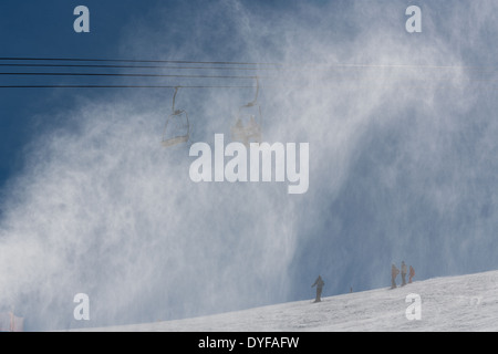 Irrorazione di innevamento artificiale neve sulle piste per sciatori in montagna Foto Stock