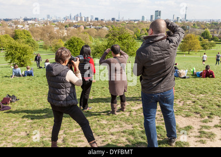 Opportunità fotografica. Le persone che hanno preso le foto del London skyline della città da Primrose Hill, London, England, Regno Unito Foto Stock