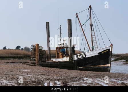 Una piccola barca da pesca legato in un torrente vicino Blakeney, Norfolk. Inghilterra Foto Stock