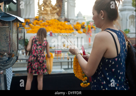 Bangkok in Thailandia - Persone di incenso di illuminazione per buona fortuna presso un santuario. Foto Stock