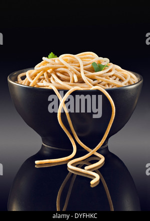 Spaghetti integrali nel vaso nero Foto Stock