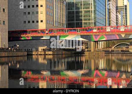 DLR un treno attraversa un ponte a Canary Wharf. Il britannico Financial Centre in Docklands, East London, England, Regno Unito. Foto Stock