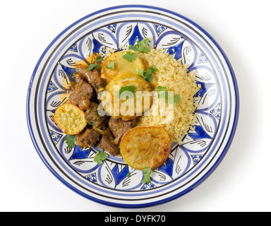 Carni bovine e la patata dolce tagine con couscous e un coriandolo guarnire su una artigianale di nord-africani piastra, un piatto marocchino da Fez Foto Stock