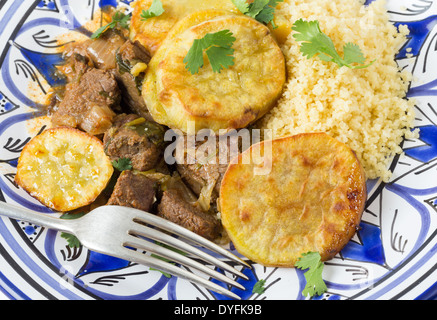 Marocchina di patata dolce e carni bovine tagine con cuscus, primo piano su una piastra con una forchetta. Un piatto tradizionale da Fez Foto Stock