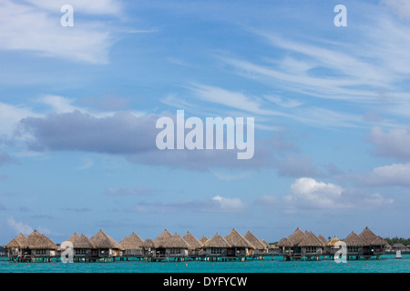 Bungalow Overwater con big sky e acqua turchese in Bora Bora, Polinesia Francese Foto Stock