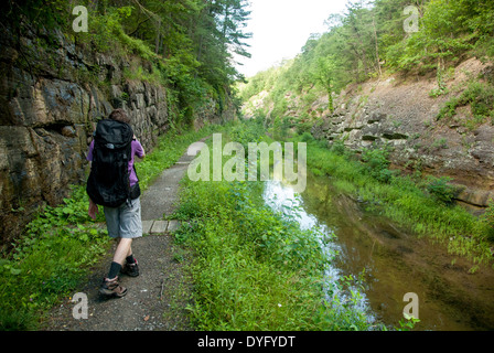 Uomo che cammina con lo zaino colmo verde foresta di Stato C&O Canal Paw Paw Tunnel Foto Stock