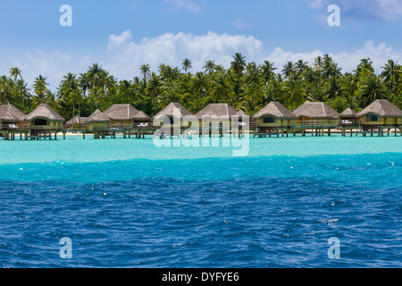 Bungalow Overwater al di sopra di strati di blu e acque turchesi sull isola di Tahaa nella Polinesia francese Foto Stock